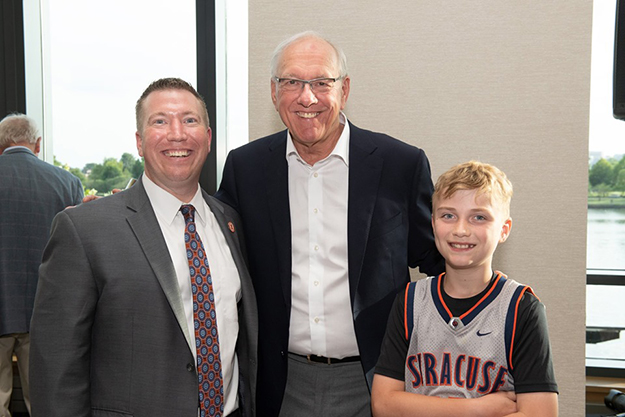Head Men's Basketball Coach Jim Boeheim (center) poses for a photo with Doug Smith '98 (L) and his son, Cam (R).